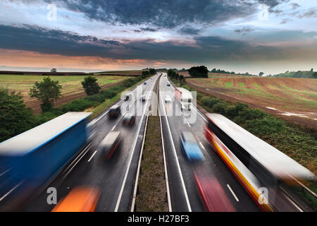 Forme sfocate di movimentazione di veicoli sulla trafficata autostrada rurale Foto Stock