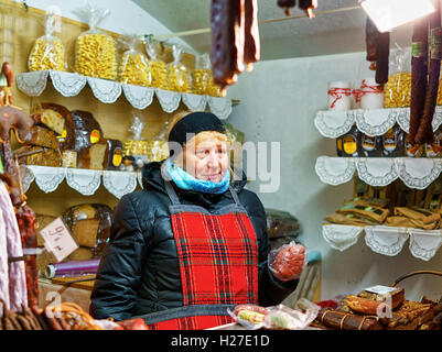 Riga, Lettonia - 24 dicembre 2015: Donna mentre trading a Riga Mercatino di Natale. A questo popolo di stallo sono stati in grado di acquistare tradizionale pane lettone, dolci, carni e salsicce. Foto Stock