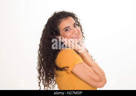 Felice giovane donna le mani sul viso con espressione sorpresa sorridente Foto Stock