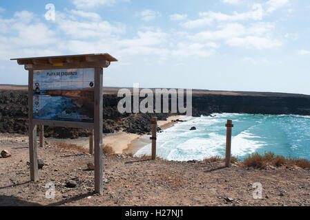 Fuerteventura: vista del segno e la spiaggia di Playa de Esquinzo, una delle più famose spiagge della costa nord occidentale per gli amanti del surf Foto Stock