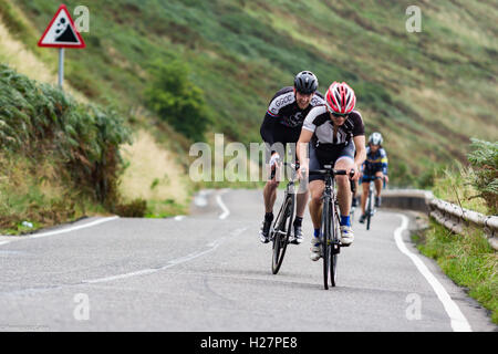 Accelerando professionalmente vestito ciclisti sull'asfalto durante il concorso in Scozia Foto Stock