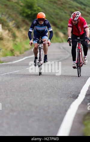 Accelerando professionalmente vestito ciclisti sull'asfalto durante il concorso in Scozia Foto Stock