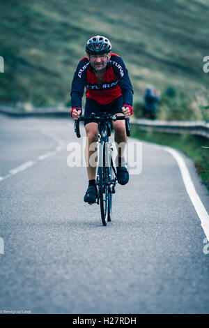 Accelerando professionalmente vestito ciclisti sull'asfalto durante il concorso in Scozia Foto Stock