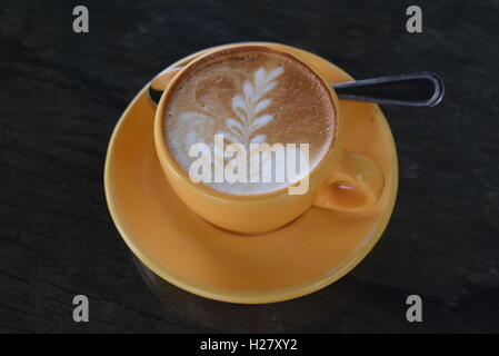 Tazza di cappuccino o latte macchiato di caffè con cucchiaino e decorazione in foglia a Finca a Filadelfia, Antigua, Guatemala Foto Stock