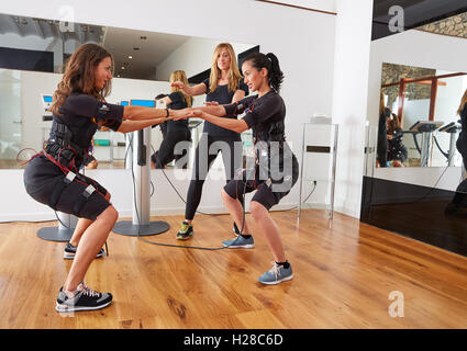 EMS elettrostimolazione donne esercita con trainer coach Foto Stock