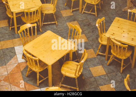 Con sedie in legno e tabelle in un vuoto di ristorante interno Foto Stock