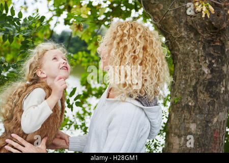 Madre e figlia parlando e giocando al parco in autunno Foto Stock
