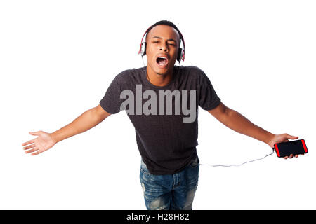Bel ragazzo africano felicemente a cantare mentre si ascolta la musica, su bianco. Foto Stock