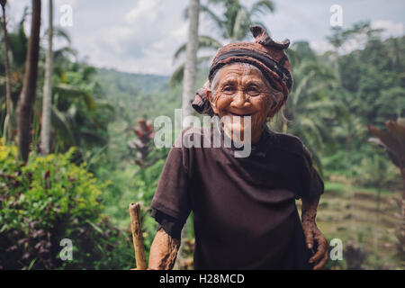 Ritratto di felice donna senior con una canna da zucchero nel villaggio. Sorridente femmina vecchio all'aperto in campagna. Foto Stock
