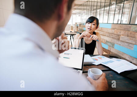 Colpo di due imprenditori a discutere di lavorare mentre si è seduti in ufficio. Donna in riunione con office manager. Foto Stock