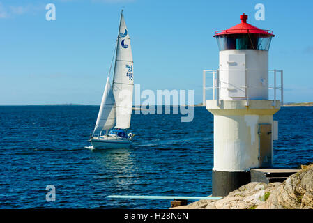 Mollosund, Svezia - 9 Settembre 2016: ambientale documentario del faro con barca a vela che arrivano. Foto Stock