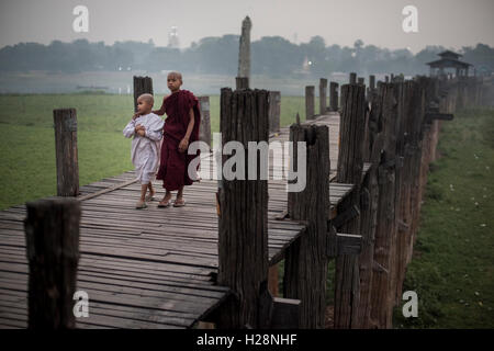 Due giovane debuttante i monaci buddisti camminando sulla U Bein Bridge in Amarapura, Myanmar. Foto Stock