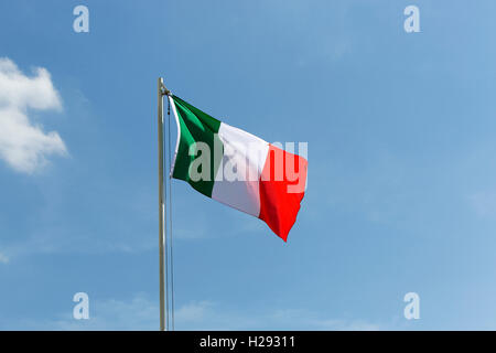 Bandiera nazionale dell'Italia su un pennone di fronte blu cielo Foto Stock