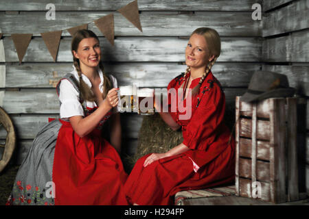 Oktoberfest belle donne azienda boccali da birra fieno Foto Stock