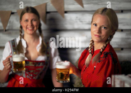 Oktoberfest belle donne azienda boccali da birra fieno Foto Stock