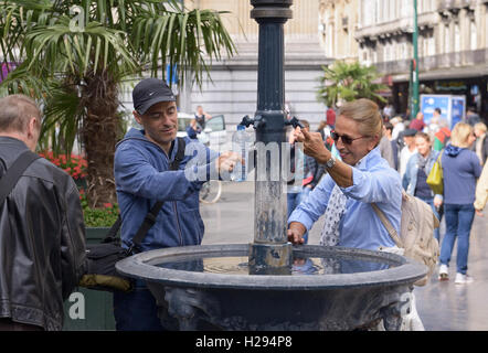 Persone non identificate hanno prendere l'acqua dalla fontana della città vicino alla Grand Place nella calda giornata di Folklorissimo 2016 Festa Folcloristica e Weeke Foto Stock