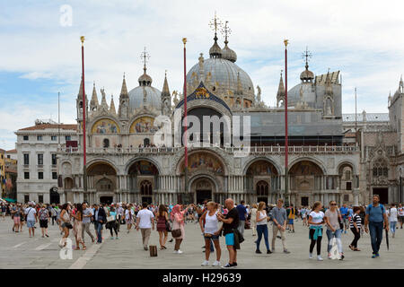 Turisti in piazza San Marco di fronte alla Basilica di San Marco di Venezia in Italia. Foto Stock