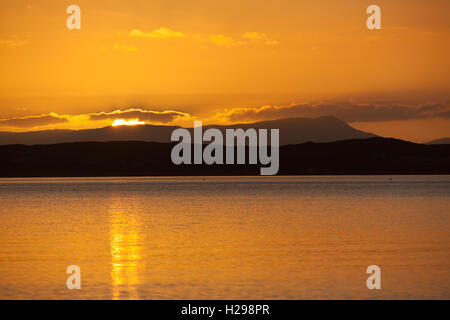 L'isola di Gigha, Scozia. Suggestivo tramonto sul suono di Gigha, con l'isola di Gigha in background. Foto Stock