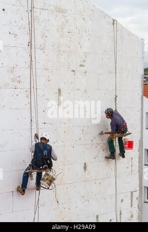 Lavoratori qualificati che lavorano in un muro di casa. Foto Stock