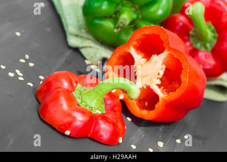 Rosso e peperoni verdi con semi tagliato a bordo Foto Stock