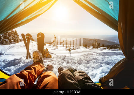 Gli appassionati di snowboard in posa sul cielo blu sullo sfondo di montagne Foto Stock