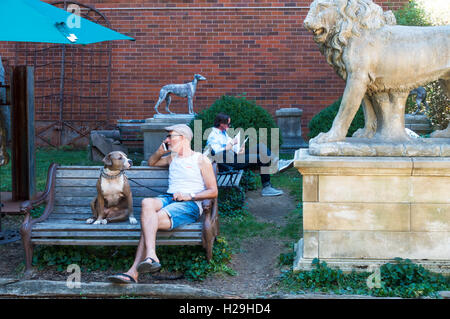 Uomo anziano con il suo cane pitbull che si rilassa in Elizabeth Street Giardino a Nolita Foto Stock