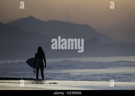 Denpasar, Bali, Indonesia. 24Sep, 2016. BALI, Indonesia - 24 settembre : un surfista a Keramas sulla spiaggia di Settembre 24, 2016 a Bali, Indonesia. Bali è una destinazione turistica popolare, che ha visto un significativo aumento di turisti sin dagli anni ottanta. È rinomato per il suo altamente sviluppato arti, tra cui la tradizionale e danza moderna, scultura, pittura, pelle, lavorazione dei metalli e la musica. L'Indonesian International Film Festival si tiene ogni anno a Bali. © Sijori Immagini/ZUMA filo/Alamy Live News Foto Stock