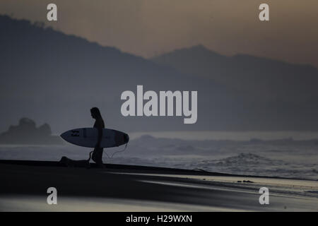 Denpasar, Bali, Indonesia. 24Sep, 2016. BALI, Indonesia - 24 settembre : un surfista a Keramas sulla spiaggia di Settembre 24, 2016 a Bali, Indonesia. Bali è una destinazione turistica popolare, che ha visto un significativo aumento di turisti sin dagli anni ottanta. È rinomato per il suo altamente sviluppato arti, tra cui la tradizionale e danza moderna, scultura, pittura, pelle, lavorazione dei metalli e la musica. L'Indonesian International Film Festival si tiene ogni anno a Bali. © Sijori Immagini/ZUMA filo/Alamy Live News Foto Stock