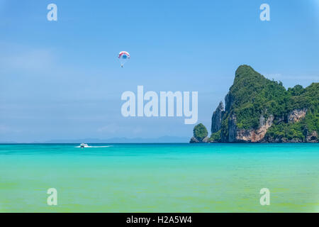 Tourist parasailing su Ko Phi Phi Don Beach con la montagna in background Foto Stock