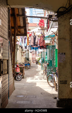 Hutong con panni appesi e le biciclette parcheggiate a Shanghai in Cina Foto Stock