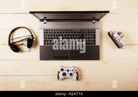 Scrivania da ufficio, computer, auricolari e gamepad, vista dall'alto Foto Stock
