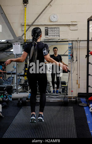 Giovane donna che lavora fuori in una palestra utilizzando una corda da salto England Regno Unito Foto Stock