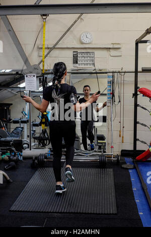 Giovane donna che lavora fuori in una palestra utilizzando una corda da salto England Regno Unito Foto Stock