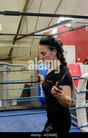 Giovane donna che lavora fuori in una palestra utilizzando una corda da salto England Regno Unito Foto Stock