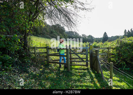 Donna che cammina su un sentiero publc, in campo vicino Pentyrch, nord, Cardiff South Glamorgan, Wales, Regno Unito Foto Stock