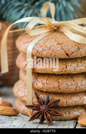 Spiced biscotti con le mandorle. Regali di natale. Round di cookie, legate con nastro e ramo di abete rosso in un cestino sul tavolo Foto Stock