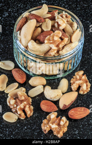 Sgusciate i dadi misti in un recipiente scuro dello sfondo Foto Stock