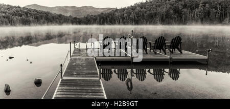 In bianco e nero il panorama del Lago di cuore il dock in una nebbiosa mattina in alte vette regione dell'Adirondack vicino a Lake Placid, NY Foto Stock