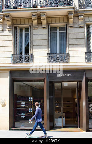 L'uomo cammina in moto mosse da uno dei luxury brand della moda del negozio nel quartiere di Le Marais a Parigi. Foto Stock