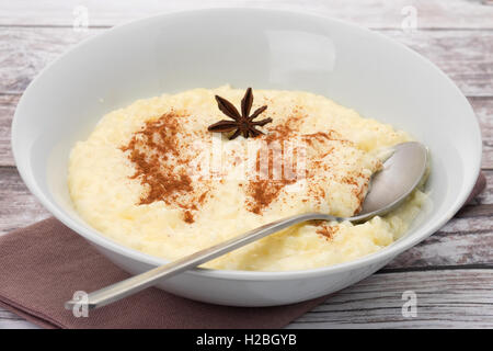 Una ciotola di crema di budino di riso che è stata spolverata di cannella in polvere. Foto Stock
