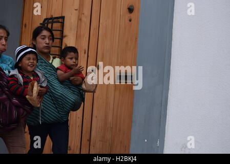 I giovani indigeni alle madri che trasportano i loro bambini per le strade di Antigua, Guatemala Foto Stock