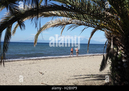 Un giovane a piedi lungo la spiaggia di Nea Moudania, Macedonia, Grecia Foto Stock