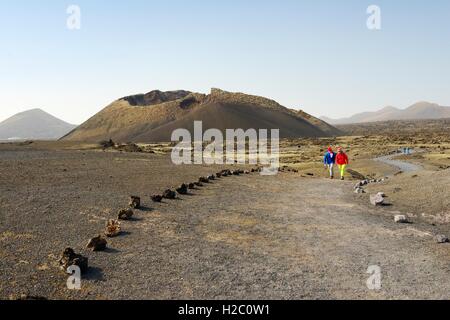 Attraversando il campo di scorie a cono vulcanico della Caldera de los Cuervos. Parco Nazionale di Timanfaya, Lanzarote, Isole Canarie, Spagna Foto Stock