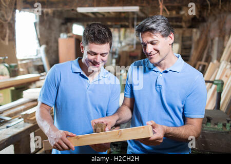 Carpenter insegnamento apprendista come legno di misura Foto Stock