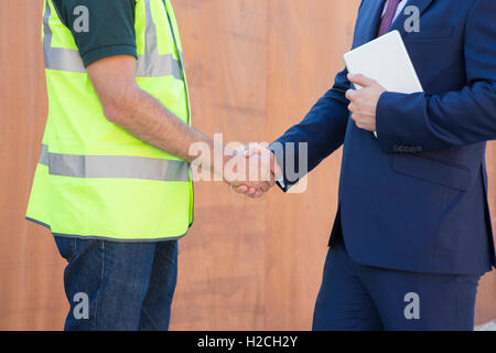 Imprenditore stringono le mani con Builder sul sito in costruzione Foto Stock