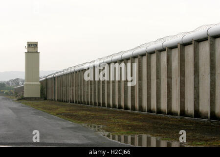 Una torre di avvistamento e parete perimetrale segna il confine dell'ex carcere di Maze, a ovest di Belfast in Irlanda del Nord, Regno Unito Prigione Foto Stock