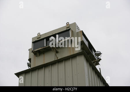 Una torre di avvistamento e parete perimetrale segna il confine dell'ex carcere di Maze, a ovest di Belfast in Irlanda del Nord, Regno Unito Prigione Foto Stock