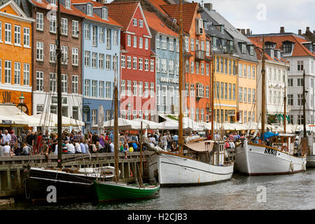 Folla turistica porto Nyhavn Copenhagen Danimarca. Architettura e design vecchio stile Foto Stock