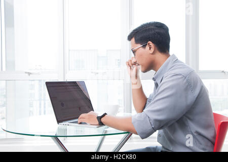 Imprenditore lavorando sul computer portatile in ufficio Foto Stock