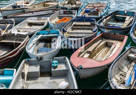 Colorate barche a remi legati assieme in un porto della Cornovaglia Foto Stock